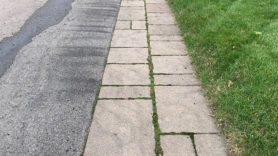 Before and after of weeds removed from patio stone - After